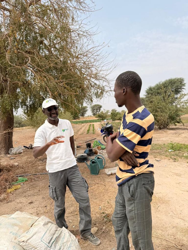 Agent Suqali Mbay Mi en discussion avec un producteur agricole au Sénégal